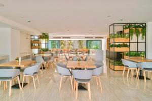 a restaurant with tables and chairs in a room at Fourium Pattaya Hotel and Serviced Residence in Pattaya South