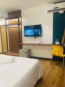 a bedroom with a bed and a tv on a wall at New Glow Hotel Miri Previously known as Citi Hotel in Miri +27 photos