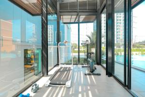 an indoor gym with treadmills and a swimming pool at Fourium Pattaya Hotel and Serviced Residence in Pattaya South