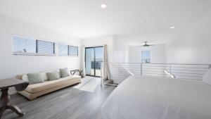 a white bedroom with a large bed and a couch at Strand Way A B by AvantStay in Oceano