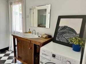a bathroom with a sink and a mirror and a washing machine at Clare Cottage on Wendouree in Clare +19 photos