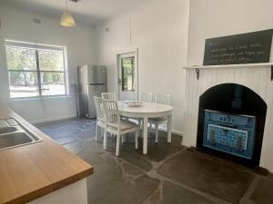 a dining room with a table and a fireplace at Clare Cottage on Wendouree in Clare