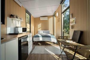 a small kitchen with a bed and a table with a laptop at The Mini Chalet by Tiny Away in Bromfleet