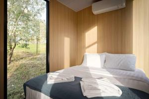 a bedroom with a bed with two towels on it at The Mini Chalet by Tiny Away in Bromfleet