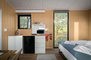 a kitchen with a microwave and a bed in a room at The Mini Chalet by Tiny Away in Bromfleet