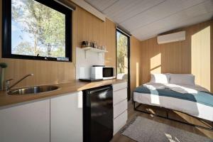 a kitchen with a bed and a sink in a small room at The Mini Chalet by Tiny Away in Bromfleet +12 photos