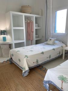 a bedroom with a bed with palm trees on it at Lobster House Antiparos in Antiparos
