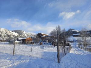 a fence covered in snow next to a building at Tusheti Winter Home in Omalo