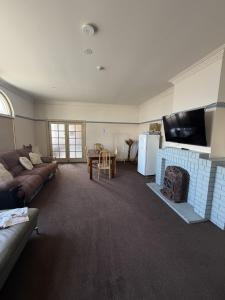 a living room with a couch and a fireplace at Coffs Harbour Hotel in Coffs Harbour