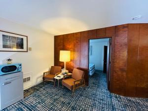 a hotel room with two chairs and a table at Curly Redwood Lodge in Crescent City