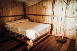 a bedroom with a bed in a wooden room at Toucan Lodge Amazon Rainforest Retreat in Tarqui