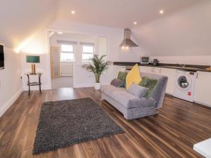 a living room with a couch and a washing machine at The Loft - 96B in Articlave