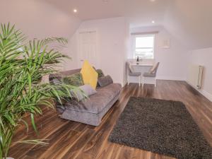 a living room with a couch and a table at The Loft - 96B in Articlave