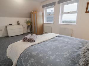 a bedroom with a bed with towels on it at The Loft - 96B in Articlave