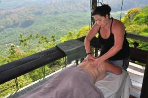 a woman is giving a man a massage at Volare in Turrialba