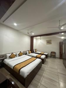 a room with two beds and a couch and chairs at Staykart Lotus in Bhilwara +111 photos