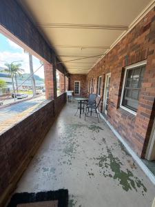 an empty patio with two chairs and a brick wall at Coffs Harbour Hotel in Coffs Harbour
