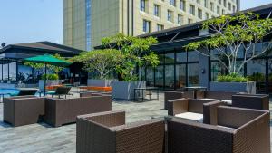 a courtyard with tables and chairs and a building at Wyndham Opi Hotel Palembang in Palembang