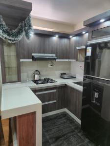 a kitchen with wooden cabinets and a black refrigerator at Marito in Juliaca