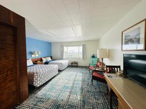 a hotel room with two beds and a television at Curly Redwood Lodge in Crescent City