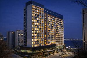 a tall building with lights on in a city at Sky Stay in Incheon