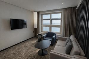a living room with a couch and a tv at Sky Stay in Incheon