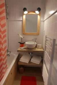 a bathroom with a sink and a tub and a mirror at Jour De Peuf in Champagny-en-Vanoise