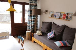 uma sala de estar com um sofá com almofadas em Jour De Peuf em Champagny-en-Vanoise