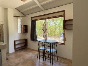 a table and two chairs in a room with a window at Malinao Beachfront Studio, Starlink, Solar in General Luna