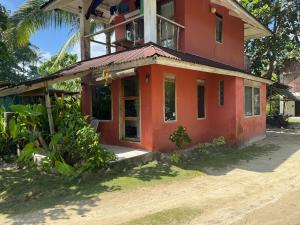 a red house on a dirt road at Malinao Beachfront Studio, Starlink, Solar in General Luna