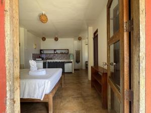a bedroom with a white bed and a kitchen at Malinao Beachfront Studio, Starlink, Solar in General Luna