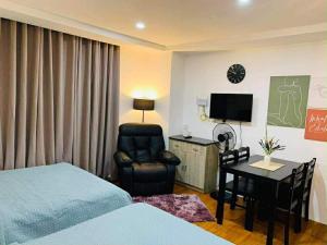 a bedroom with a bed and a chair and a desk at EA Staycation in Baguio +14 photos