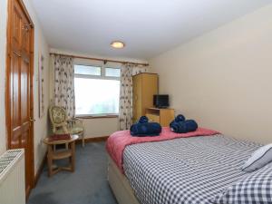 a bedroom with a bed with two blue bags on it at Min Y Traeth in Amlwch