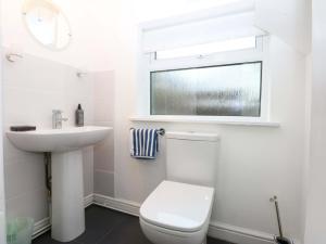 a bathroom with a toilet and a sink and a window at Min Y Traeth in Amlwch +20 photos