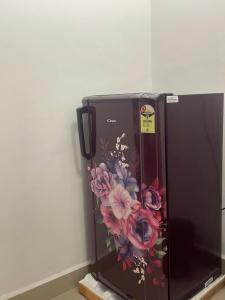 a black microwave with flowers painted on the side of it at Vista Maria Guesthouse in Dona Paula