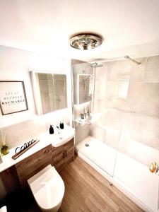 a bathroom with a shower and a toilet and a sink at Harbour Hideaway, Porthleven in Porthleven +15 photos