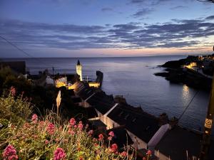 a view of a city with a clock tower and the water at Harbour Hideaway, Porthleven in Porthleven