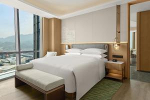 a bedroom with a large bed and a large window at Courtyard by Marriott Yibin in Yibin +98 photos