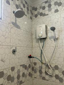 a bathroom with a shower with a blow dryer at Homestay Stay Kartoon Pantai Merdeka in Kampong Pengkalan Batu Lintang +40 photos