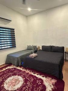 a bedroom with two beds and a rug at Homestay Stay Kartoon Pantai Merdeka in Kampong Pengkalan Batu Lintang