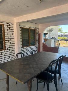 a table and chairs in a room with a brick wall at Homestay Stay Kartoon Pantai Merdeka in Kampong Pengkalan Batu Lintang