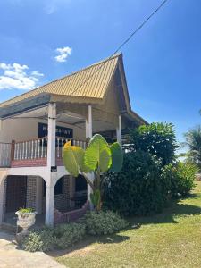 a building with a plant in front of it at Homestay Stay Kartoon Pantai Merdeka in Kampong Pengkalan Batu Lintang