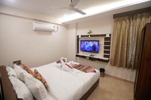 a bedroom with a bed and a tv in it at Suncrisp Studio Rooms in Pedda Waltair