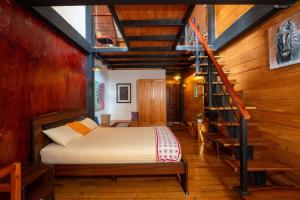 a bedroom with a bed and a staircase at Amansara Bungalow - Panoramic Lake View Villa, Nuwara Eliya in Nuwara Eliya +32 photos
