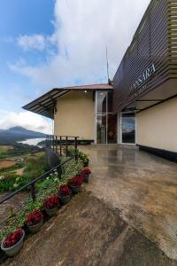a building with pots of plants in front of it at Amansara Bungalow - Panoramic Lake View Villa, Nuwara Eliya in Nuwara Eliya
