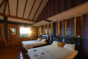 a bedroom with two beds and a window in it at Amansara Bungalow - Panoramic Lake View Villa, Nuwara Eliya in Nuwara Eliya