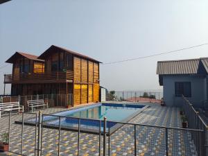 a house with a swimming pool next to a building at Royal Shouryas Resort in Kolhapur