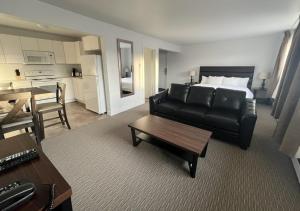 a living room with a couch and a bed and a table at Anavada Inn & Suites - Prince George in Prince George