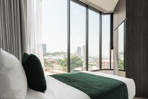 a bedroom with a bed with a large window at Hampton Sriracha in Si Racha +26 photos