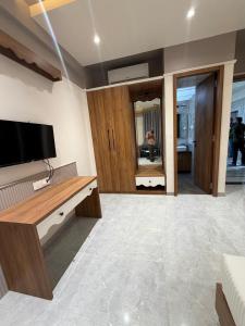 a living room with a flat screen tv on the wall at Hotel Regency Grand in Shikrapur